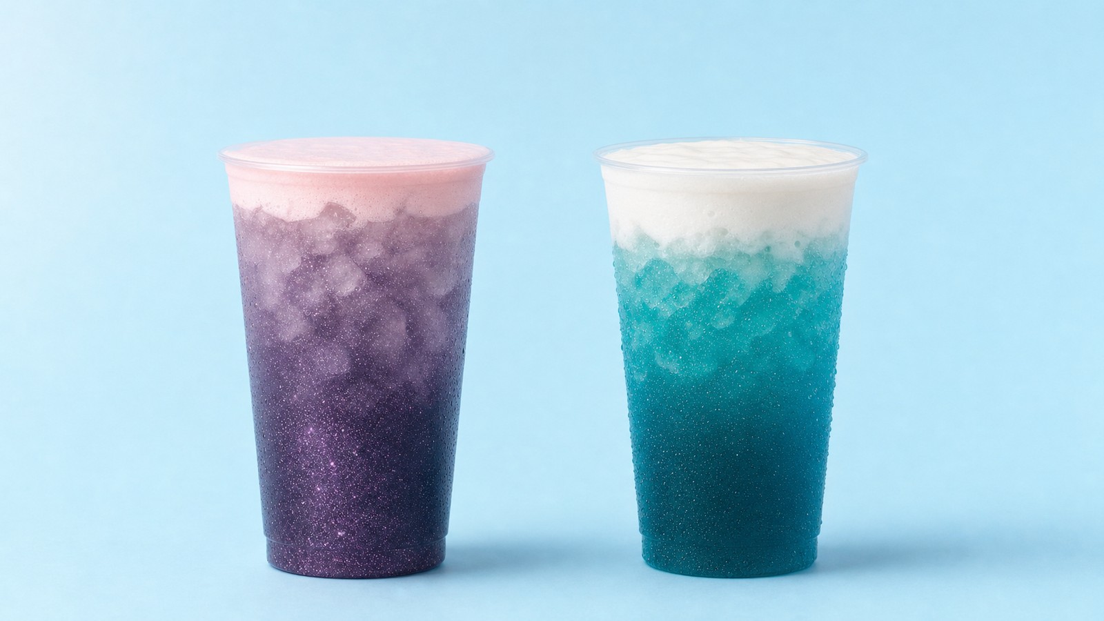 Purple Glitter and Blue Raspberry Cream dirty sodas in tall clear cups with flat lids